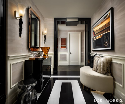 Lori Morris Design - balck and white hallway, a mirror above a console, a sofa and a side table. A rectangular mirror in black and gold and a painting in front on the other wall.