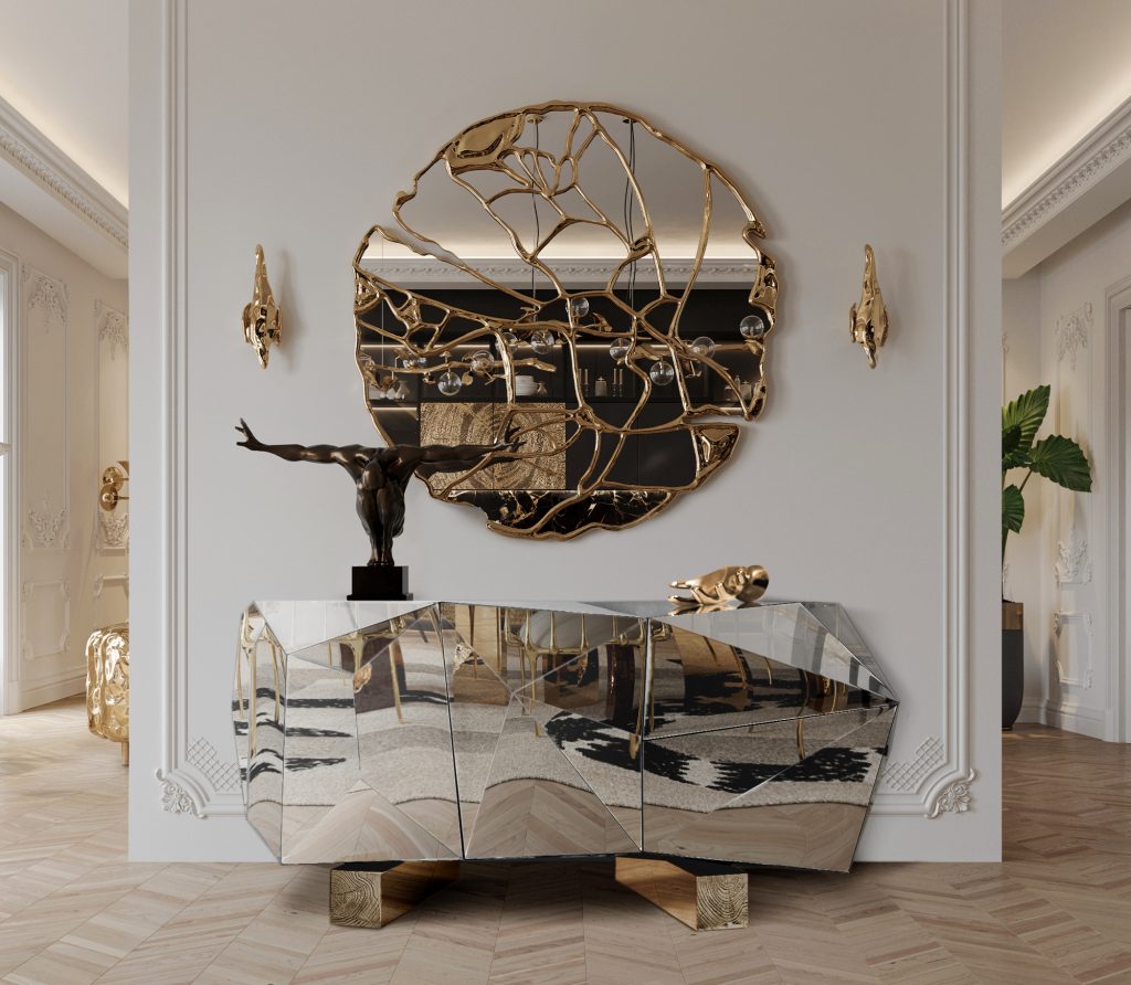 luxury entryway with round gold mirror and a silver sideboard