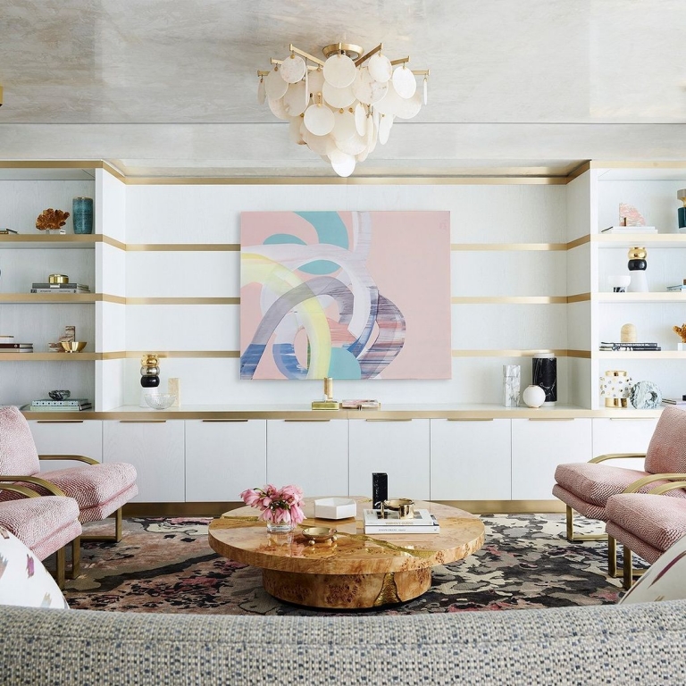 modern luxury living room with pink armchairs, colorfull board in the wall and a round poplar coffee table that is ready to go to your room
