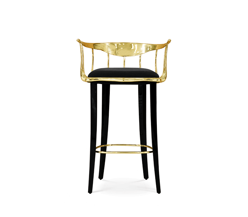 Rockwell Group - A bar Chair with black legs and gold arms and back.